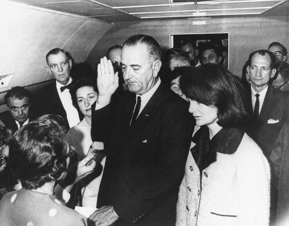 Flanked by Jackie Kennedy (R) and his wi