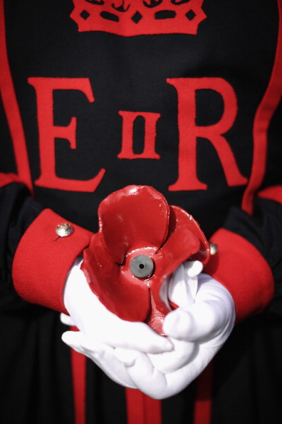 Tower Of London Beefeater Plants The First Ceramic Poppy To Commemorate WW1