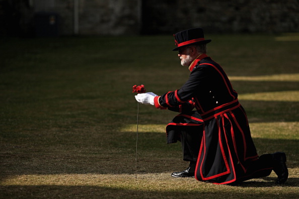 Tower Of London Beefeater Plants The First Ceramic Poppy To Commemorate WW1