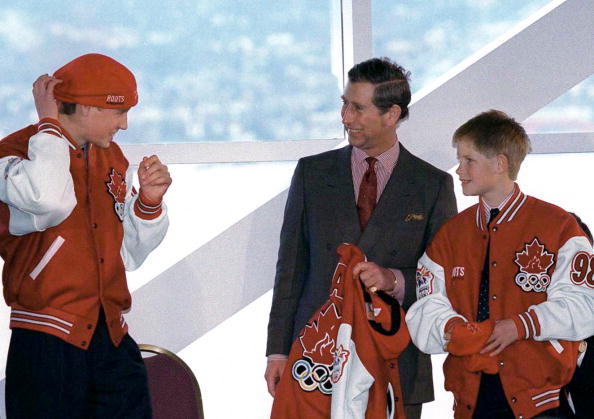 CANADA - MARCH 24: During A Visit To The Pacific Marine Heritage Legacy Prince Charles And His Sons, Prince William And Prince Harry, Were Presented With Bright Red "roots" Canadian Olympic Jackets And Baseball Caps. Showing His Sense Of Humour, Prince William Has Decided To Put His Hat On Back To Front. (Photo by Tim Graham Picture Library/Getty Images)