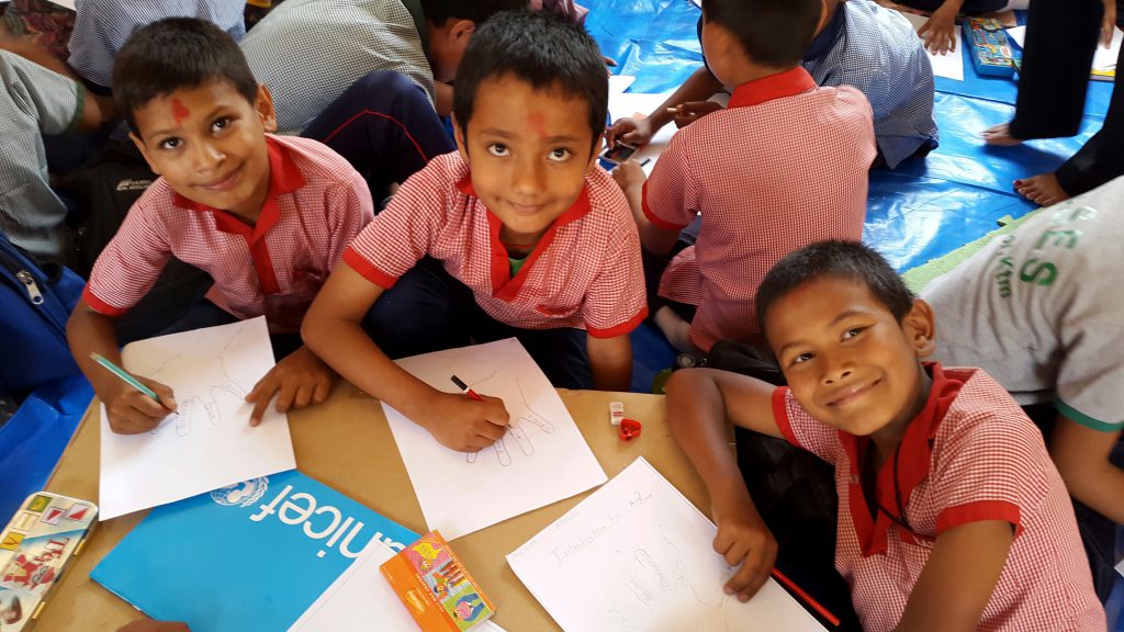 A group of boys begin their studies again at the Kuleshwor School in Kathmandu, Nepal with drawings. Children like these at the Kuleshwor School in Kathmandu, Nepal are happy to finally be back to school for the first time this morning since the first of two Nepal earthquakes which occurred on 25 April 2015. Their school was heavily damaged and is not safe to enter so the children have returned to class in temporary learning spaces built with UNICEF support. UNICEF also provided education and recreation kits for the children, along with psycho-social training for teachers  and continues to support damage assessment of schools damaged in the two Nepal Earthquakes. Back to School for first time in Nepal since first Earthquake Photos Kent Page 2015