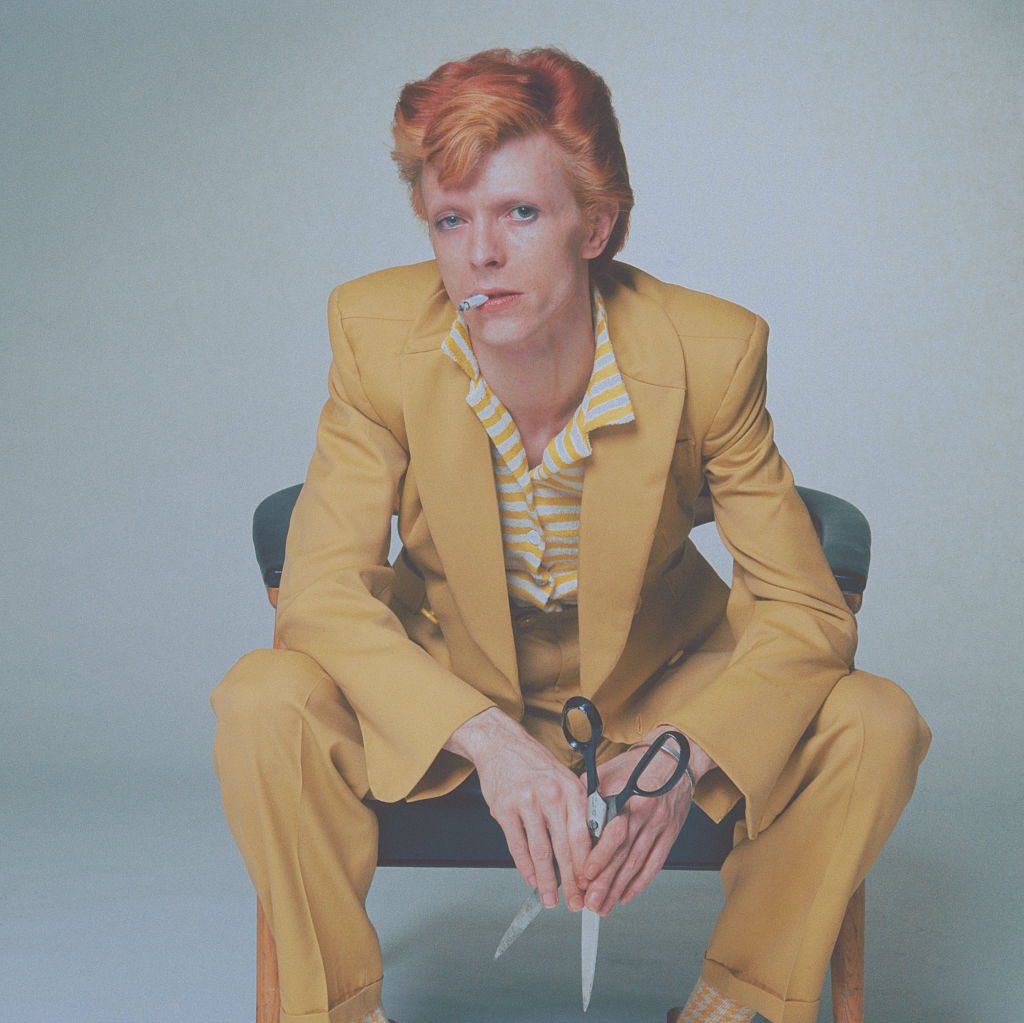 English singer, musician and actor David Bowie with dyed red hair and a yellow suit, circa 1974. (Photo by Terry O'Neill/Hulton Archive/Getty Images)