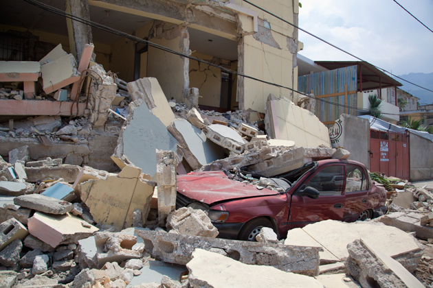 A car is crushed when a building collapses after the earthquake