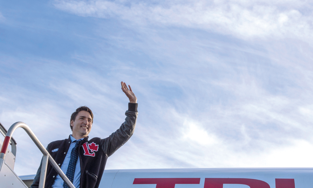 Liberal Leader Justin Trudeau waves as he boards his plane en route to Calgary, Sunday, October 18, 2015 in Edmonton. THE CANADIAN PRESS/Paul Chiasson