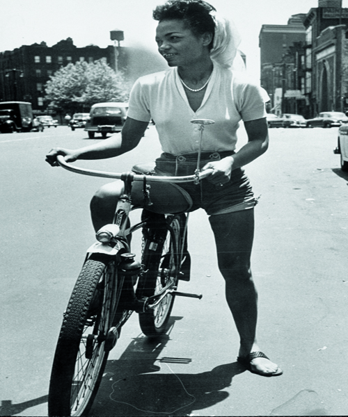 Singer Eartha Kitt riding her bicycle down the street. (Photo by Gordon Parks/The LIFE Picture Collection/Getty Images)