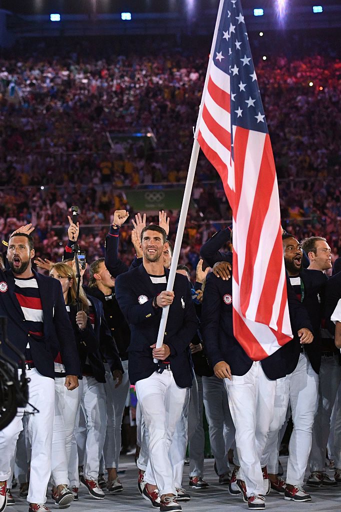 TOPSHOT - The USA's Michael Phelps carries the flag during the opening ceremony of the Rio 2016 Olympic Games at the Maracana stadium in Rio de Janeiro on August 5, 2016. / AFP / Leon NEAL (Photo credit should read LEON NEAL/AFP/Getty Images)