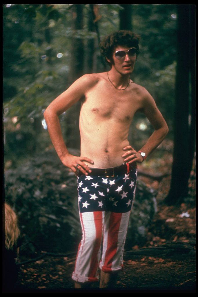 UNITED STATES - AUGUST 01: Young man wearing American Flack pants at Woodstock music festival (Photo by Bill Eppridge/The LIFE Picture Collection/Getty Images)