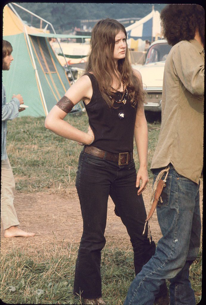Young woman member of the White Panthers, a group formed to support the work of the Black Panthers stands aside as young man sets up a tent at the Woodstock music festival, August 1969. (Photo by Ralph Ackerman/Getty Images)