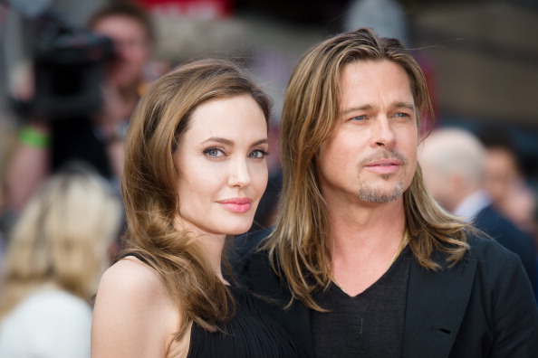 US actress and humanitarian campaigner Angelina Jolie (L) poses with her US actor and fiance Brad Pitt as she arrives for the UK premiere of Brad Pitt's latest film "World War Z" in Leicester Square in central London on June 2, 2013. Jolie, 37, revealed in an article in the May 14 edition of The New York Times that she chose to undergo surgery to minimize the risk she might develop breast cancer due to the inheritance of a "faulty gene." The actress's partner and fellow screen star Brad Pitt led worldwide praise, declaring Jolie heroic, followed by her doctors, other stars and thousands of supporters, who took to social media to praise her openness. AFP PHOTO / LEON NEAL (Photo credit should read LEON NEAL/AFP/Getty Images)
