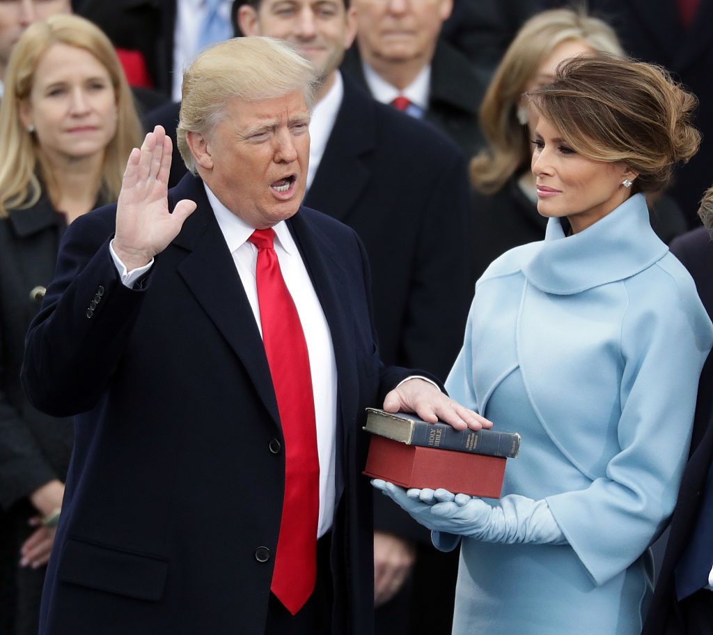 WASHINGTON, DC - JANUARY 20: (L-R) U.S. President Donald Trump takes the oath of office as his wife Melania Trump holds the bible on the West Front of the U.S. Capitol on January 20, 2017 in Washington, DC. In today's inauguration ceremony Donald J. Trump becomes the 45th president of the United States. (Photo by Chip Somodevilla/Getty Images)