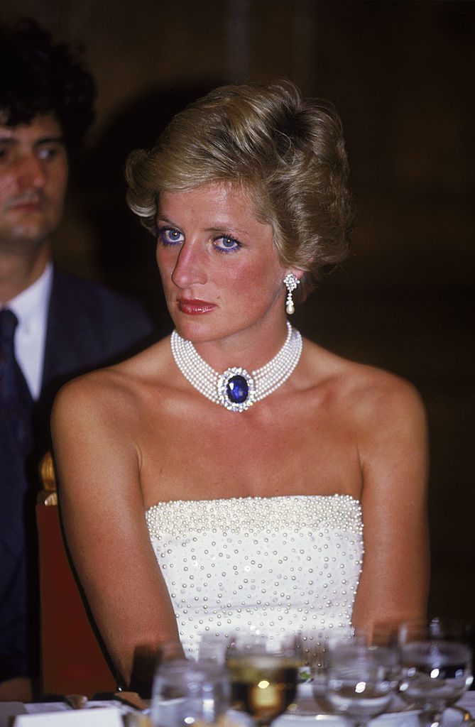 The Princess of Wales (1961 - 1997) wears a white Catherine Walker dress embroidered with pearls to a formal dinner in Budapest, 7th May 1990. She accessorises it with a pearl and sapphire choker. (Photo by Jayne Fincher/Princess Diana Archive/Getty Images)