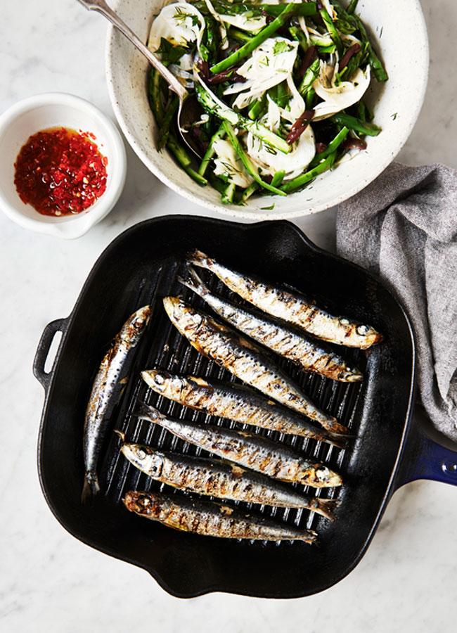 Sardines in a grill pan with a bowl of Fennel, Asparagus and Olive Salad