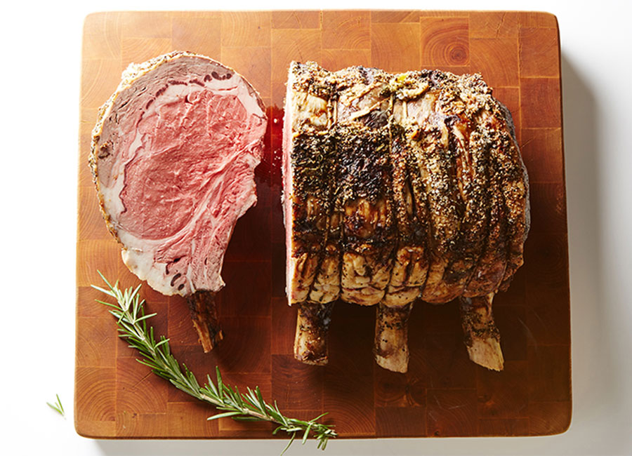 Prime rib roast beef with a slice cut out exposing the red meat. 