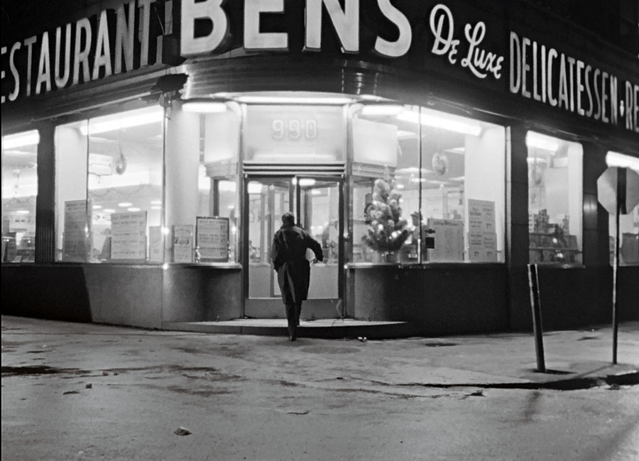 A black and white photo of Leonard Cohen entering the legendary Bens De Luxe Deli in the 1965 NFB documentary Ladies and Gentlemen...Mr. Leanard Cohen.
