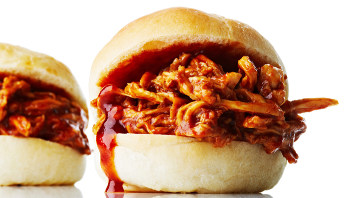 A slider full of shredded chicken soaked in barbecue sauce. 