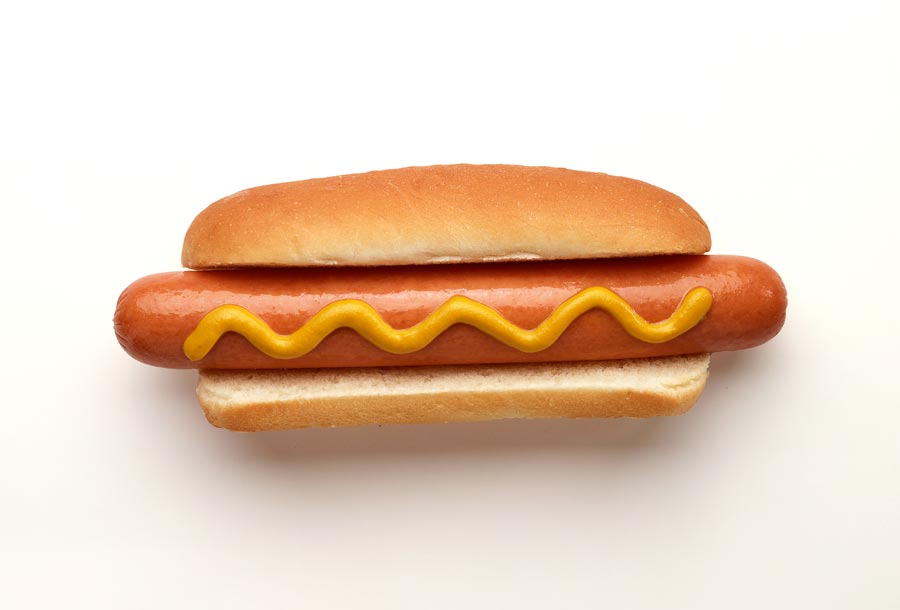Hot dog on a bun with mustard 