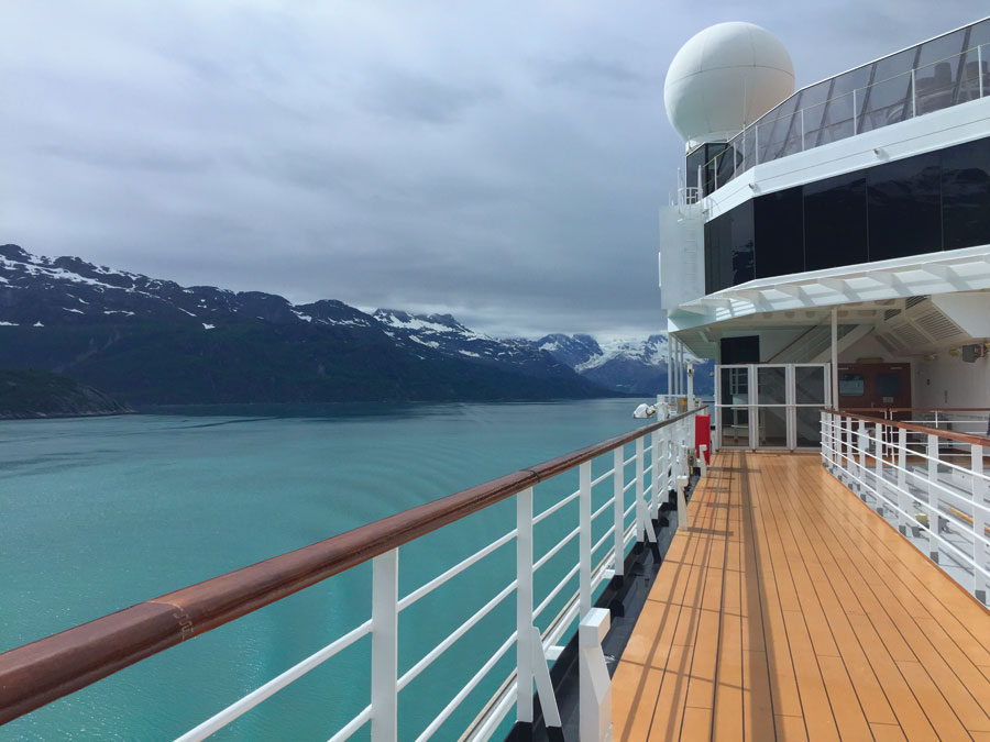 The view from the deck of ship on Opera's Alaska cruise where Turquoise water and snow capped mountains can be seen. 