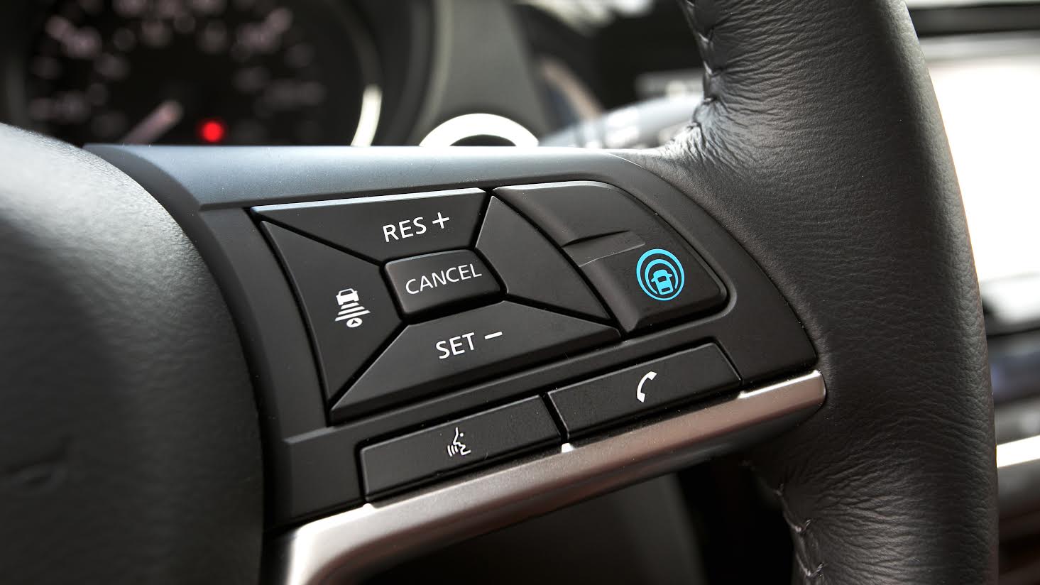 Close up of a steering wheel that features a new auto pilot feature. 