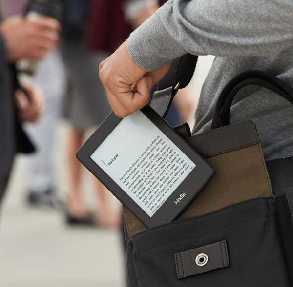 Someone pulling an eReader out of a satchel. 