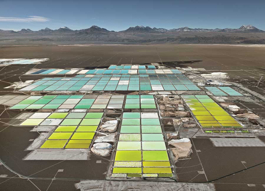 An elevated view of a lithium mine in Chile with mountains in the background. 