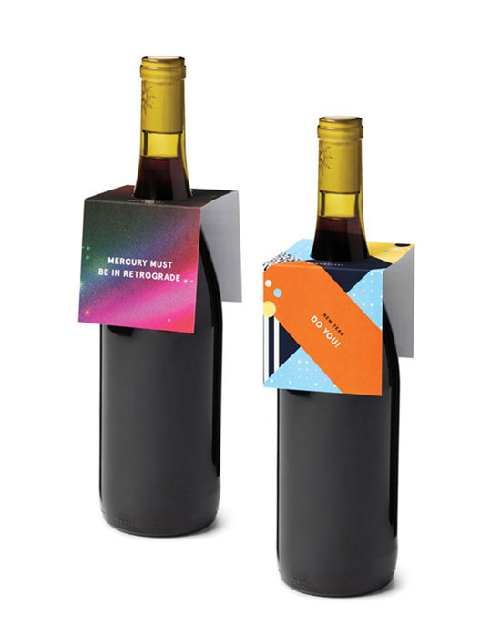 Two bottles of wine shown with gift tags around the bottle neck