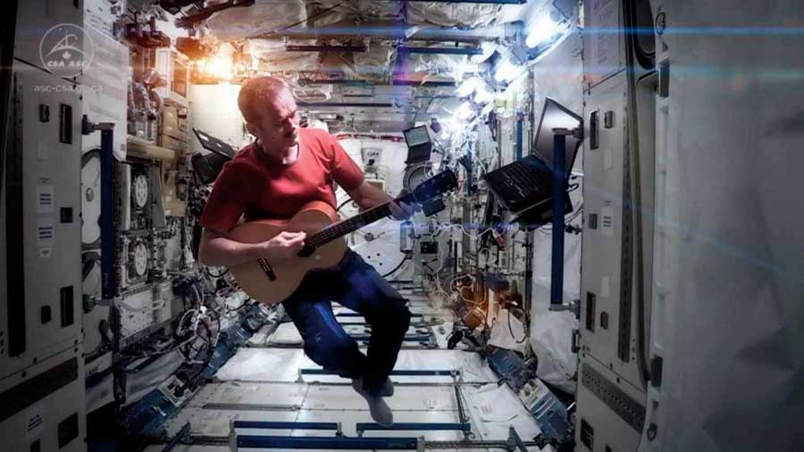 Chris Hadfield strums a guitar while floating aboard the international space station. 