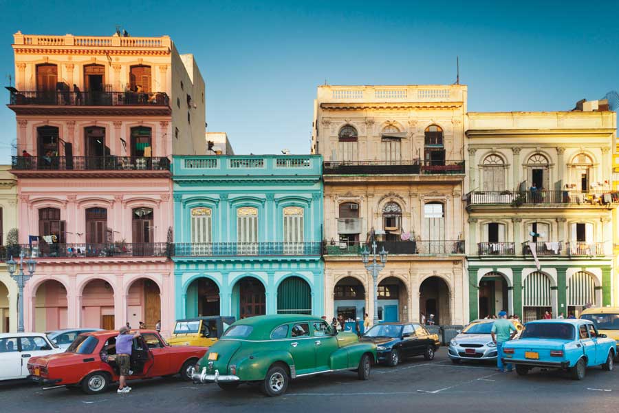 A block of colourful buildings, pink, bright blue and yellow in Old Havana. 