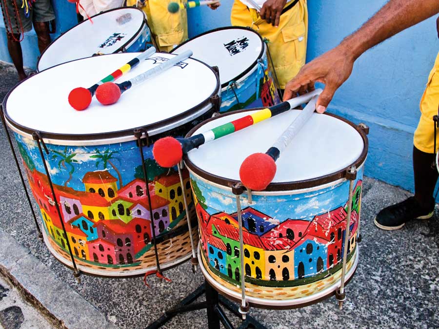 Drums with colourful houses painted on them in red, yellow, blue and green. 