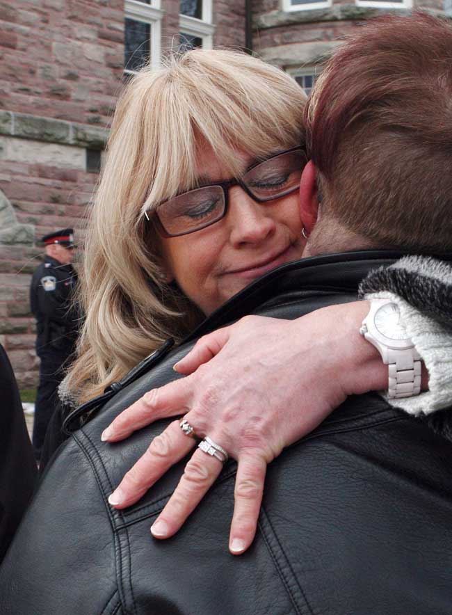 Andrea Silcox, daughter of victim Jane Silcox, is hugged by Laura Jackson, friend of victim Maurice Granat, outside the courthouse in Woodstock, Ont. on Jan. 13, 2017.