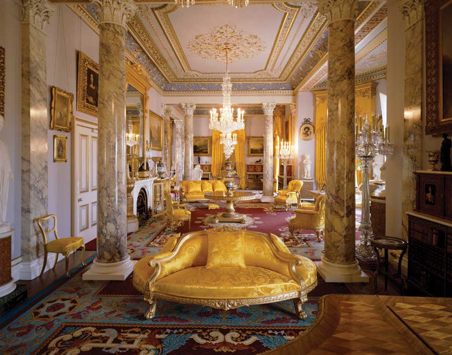 A room at the Osborne House decorated in gold furniture and marble pillars.