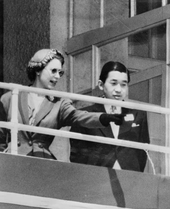 A black and white photo of Queen Elizabeth II and Crown Prince Akihito in the royal box at Epsom Downs Racecourse in England, 1953.