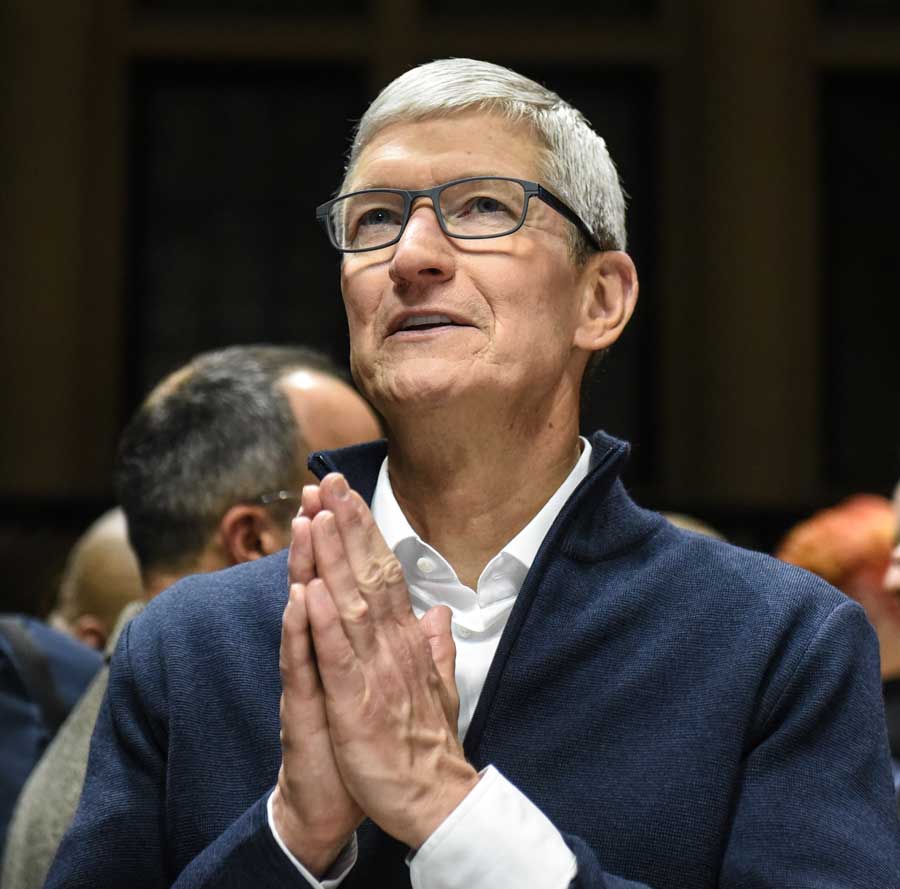 Apple CEO Tim Cook holding his hands together in prayer.