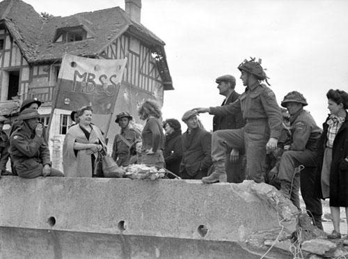 Sgt. Rosaire Gagno talking with French civilians, Bernières-sur-Mer, France, 6 June 1944.