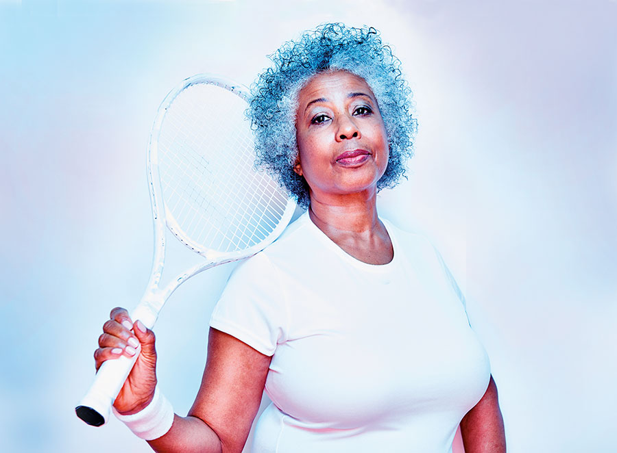 A woman with a tennis racket resting on her shoulder