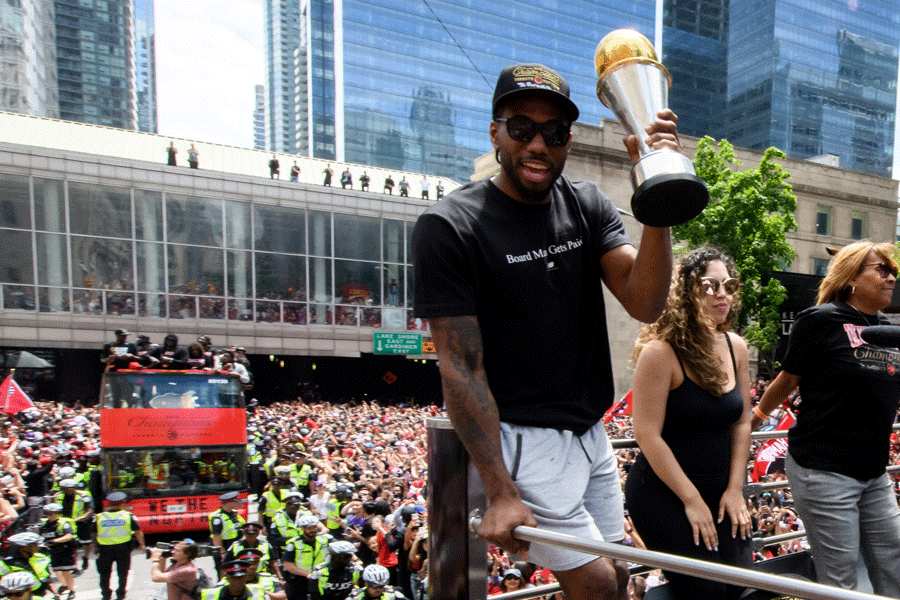 Kawhi Leonard on the Championship Parade route in Toronto holding his finals MVP trophy. 